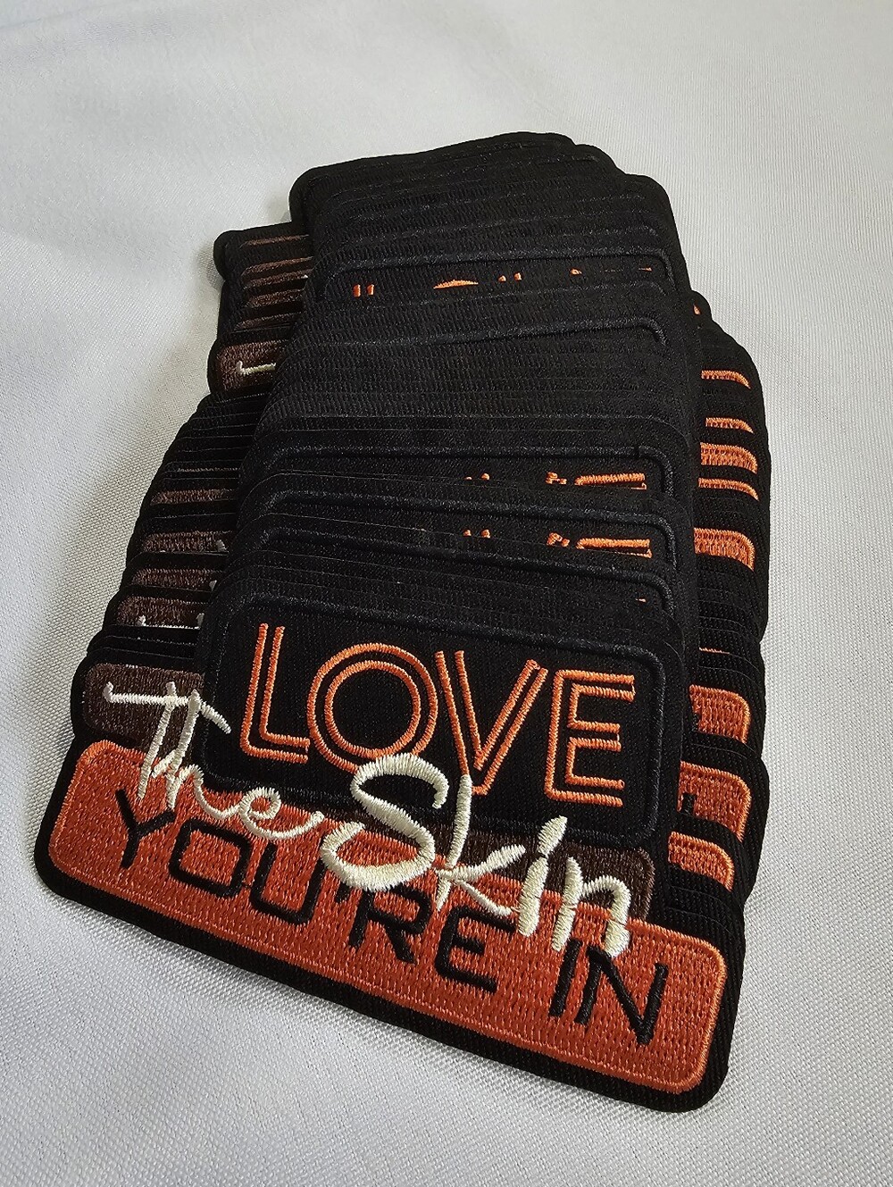 "Love The Skin You're In" Black and Orange Embroidered Patches 35 Pack